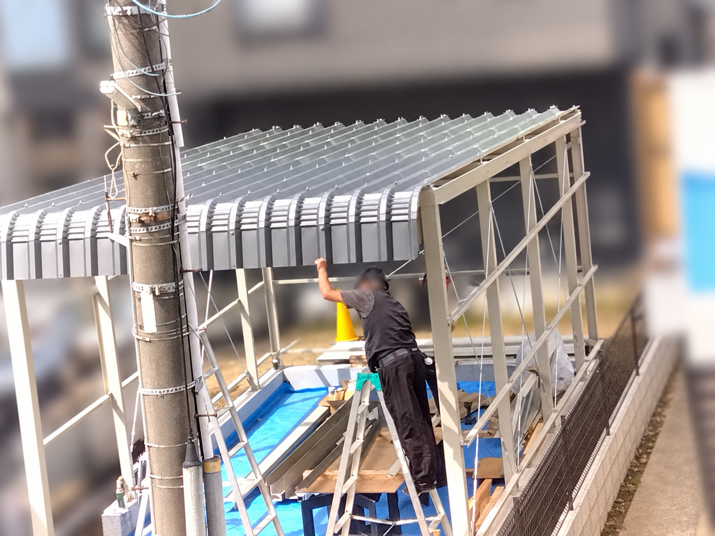 ガレージの骨組みに屋根材を施工している様子